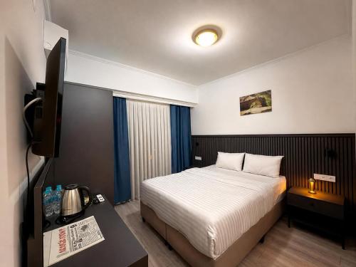 a hotel room with a bed and a television at The Yücedağ Hotel in Arapkir