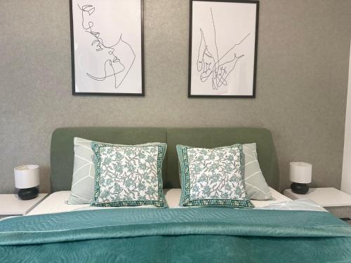 a bedroom with three pictures on the wall and a bed at Apartman Eden Divčibare in Divčibare
