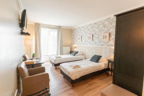 a hotel room with two beds and a chair at B&B Castellier in Lier