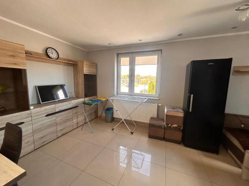 a kitchen with a refrigerator and a clock on the wall at Hostel Jagiellońska in Nowe Miasto Lubawskie