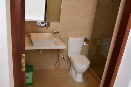 a small bathroom with a toilet and a sink at Sunset Fort Galle in Galle