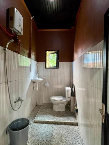 a small bathroom with a toilet and a sink at Toraja Bungin Family House in Rantepao