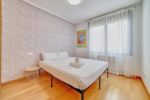 a bedroom with a large white bed with a window at Las Gaunas by Clabao in Logroño