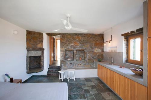 a kitchen with a stone wall and a ceiling at Kelya Houses in Kithnos