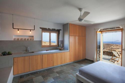 a kitchen with a bed and a sink and a window at Kelya Houses in Kithnos