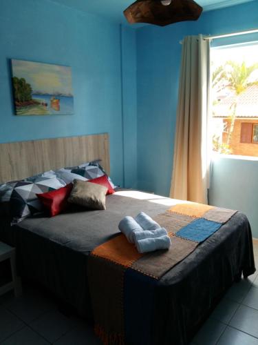 a bedroom with a bed with two towels on it at Sol da Cachoeira in Florianópolis