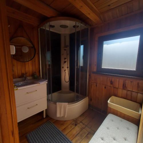 a bathroom with a shower and a tub and a sink at Zacisze in Uście