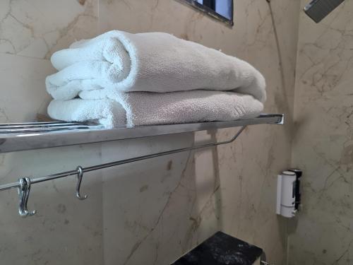 a pile of towels sitting on a shelf in a bathroom at Vrind Orchid- Near Prem Mandir in Vrindāvan
