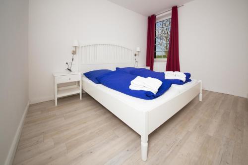 a bedroom with a bed and a table and a window at Schleiblick App 9 in Rabenkirchen-Faulück