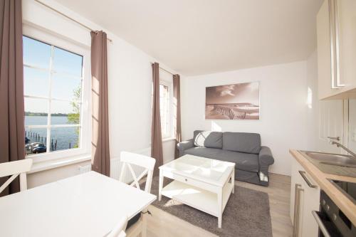 a living room with a couch and a table at Schleiblick App 11 in Rabenkirchen-Faulück