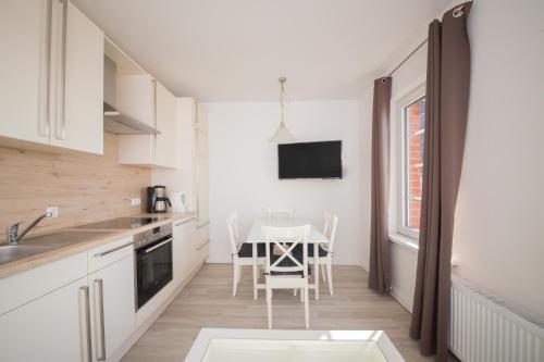 a kitchen with a table and a dining room at Schleiblick App 11 in Rabenkirchen-Faulück