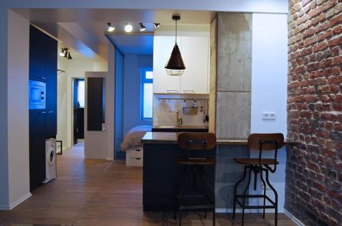cocina con fregadero y 2 taburetes en Jordan Suite Executive Furnished Apartment, en Düsseldorf