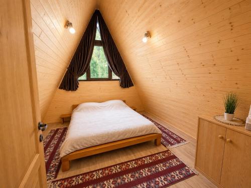 a small bed in a room with a window at Căbănuțe Izbândiș in Şuncuiuş