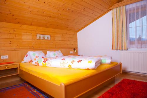 sypialnia z żółtym łóżkiem w drewnianym pokoju w obiekcie Lochgrubgut w mieście Altenmarkt im Pongau