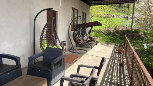 a porch with chairs and a hammock on a patio at Syunyats guest house in Halidzor