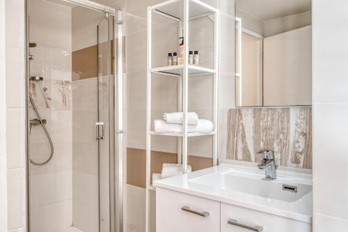 a bathroom with a white sink and a shower at Roc Hotel - Hôtel 4 étoiles les pieds dans l'eau in Le Lavandou