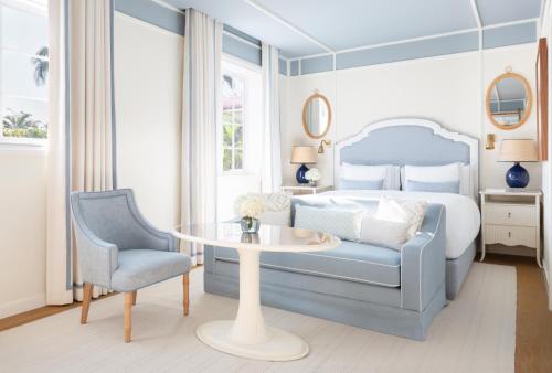 a bedroom with a bed and a table and a chair at The Vineta Hotel, Oetker Hotels in Palm Beach