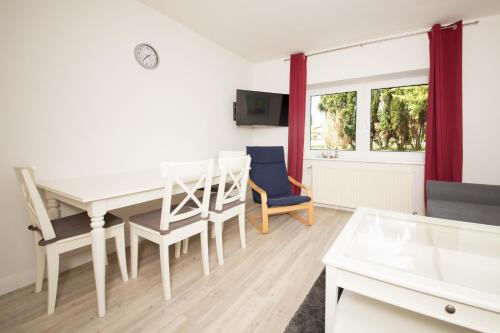 a living room with a dining room table and chairs at Schleiblick App 2 in Rabenkirchen-Faulück