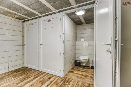 a bathroom with a toilet in a room with tiles at Campement Ô Rêves in Genouilleux