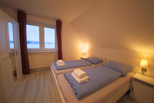 two beds in a room with two windows at Schleiblick App 7 in Rabenkirchen-Faulück