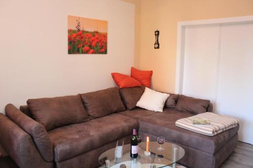a living room with a brown couch and a table at Haus Hahn in Suhlendorf
