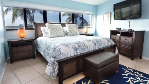 a bedroom with a bed with a large window and a television at 305 Kawama Tower in Key Largo
