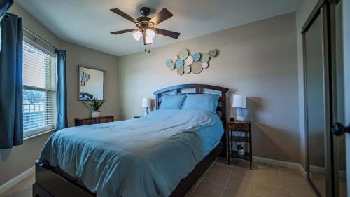 a bedroom with a bed with a ceiling fan at Treasure on Comal! in New Braunfels