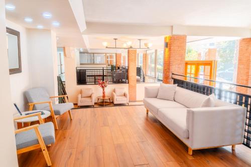 a living room with a couch and chairs on a balcony at Hotel Casa Nogales in Santiago