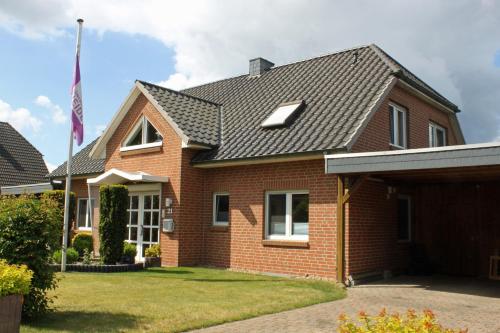 a brick house with a flag in the yard at Ferienwohnung Heuer in Ebstorf