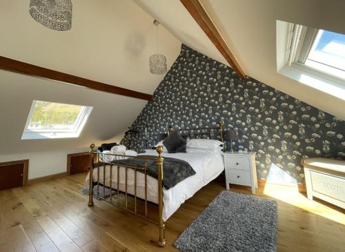 a bedroom with a bed with a black and white patterned wall at Ruby's Cottage in Threlkeld