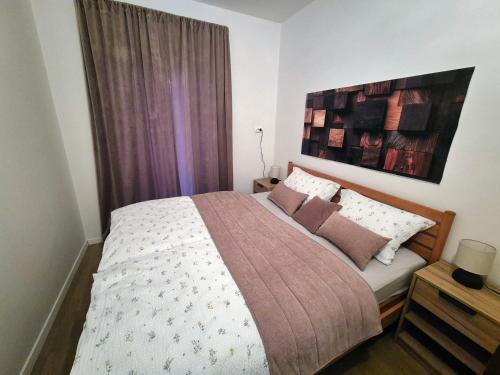 a bedroom with a bed and a large window at Apartments Makin by El-Pi Tours in Njivice