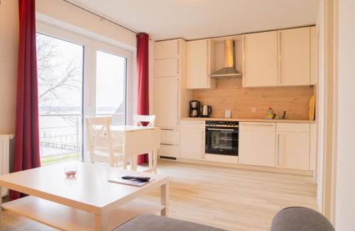 a kitchen and dining room with a table and a window at Schleiblick App 18 in Rabenkirchen-Faulück