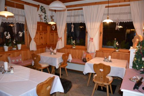 un restaurante con 2 mesas y sillas y árboles de Navidad en Hotel Gasthaus Schwarzenstein, en Ginzling