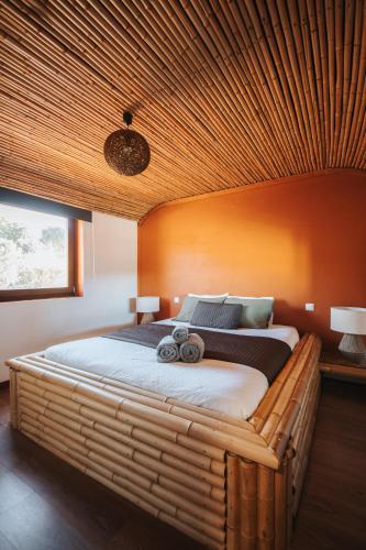 a bedroom with a large bed with a wooden ceiling at Vida Pura Apartments in Odeceixe