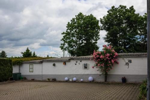 a white building with a bunch of flowers on it at Hotel-Pension am Rosarium in Sangerhausen