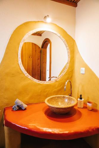 a bathroom with a bowl sink and a mirror at Vida Pura Apartments in Odeceixe