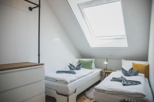a attic bedroom with two beds and a skylight at Van Senden 5 Anni in Krummhörn
