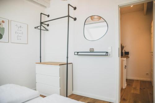 a bedroom with a white closet and a mirror at Van Senden 5 Anni in Krummhörn