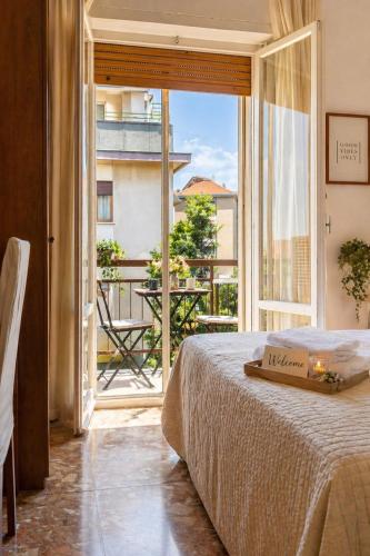 a bedroom with a bed and a large window at Mariclà Boutique Rooms with Balcony & Free Parking in Verona