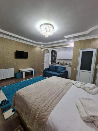 a bedroom with a large bed and a living room at Hotel Tabidze in Batumi