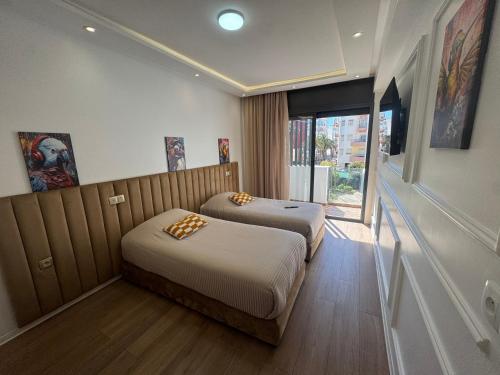two beds in a room with a window at Résidence Royal CasaBlanca in Casablanca