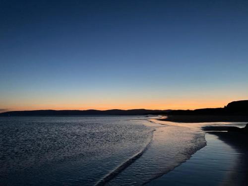 a view of a beach at sunset at Dunrigh Cottage in Blackwaterfoot