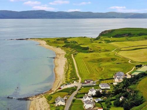 an aerial view of a golf course next to the ocean at Dunrigh Cottage in Blackwaterfoot