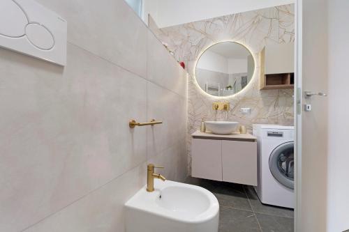 a bathroom with a sink and a washing machine at Sunset on the Lake Belgirate in Belgirate