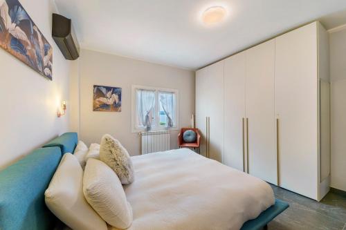 a bedroom with a large white bed with pillows at Sunset on the Lake Belgirate in Belgirate