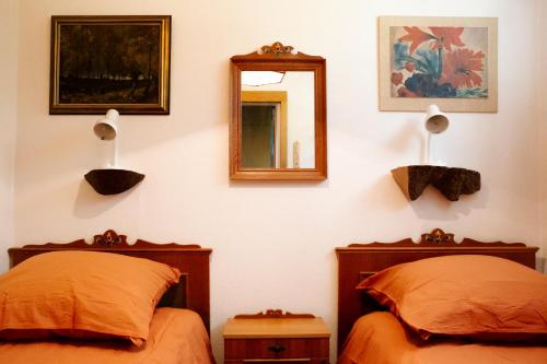 a bedroom with two beds and a mirror on the wall at Peaceful Oasis Black Forest in Schonach