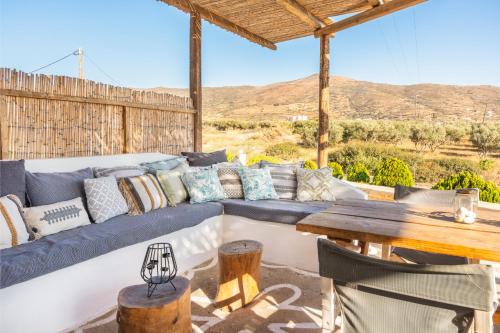 a living room with a blue couch and a wooden table at Revery Villa & House in Ios Chora
