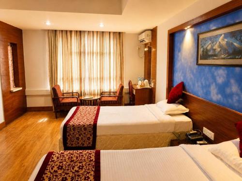 a hotel room with two beds and a table at Woodland Heritage Hotel in Kathmandu