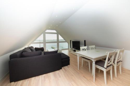 a living room with a black couch and a table at Schleitraum Appartement in Rabenkirchen-Faulück
