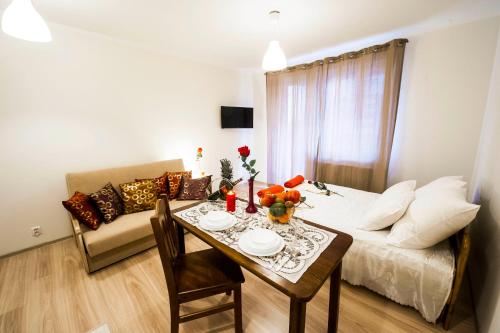 sala de estar con mesa y sofá en Apartament Polonijna en Cracovia